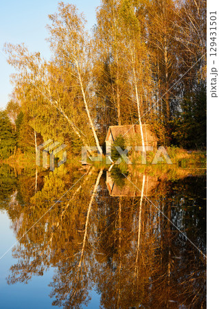 Tranquil Reflections: House and Trees Mirrored in River Tranquil Reflections: House and Trees Mirrored in River 129431501