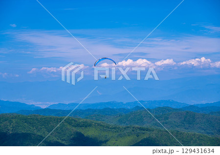 夏の空を飛ぶパラグライダー 129431634