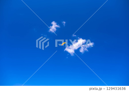 夏の青空を飛ぶパラグライダー 129431636