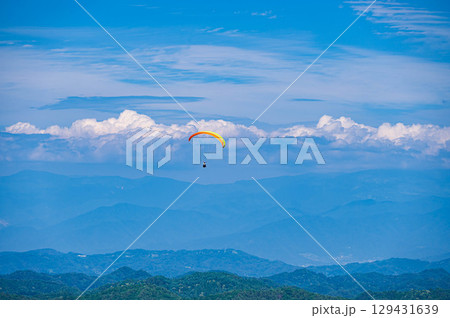 大空を飛ぶパラグライダー 129431639