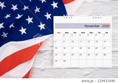 November 2026 Monthly desk calendar and United States of America flag, Flat lay. 129431890