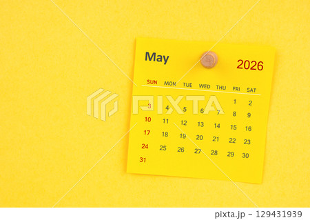 May 2026 calendar sheet with thumbtack on yellow color background. 129431939