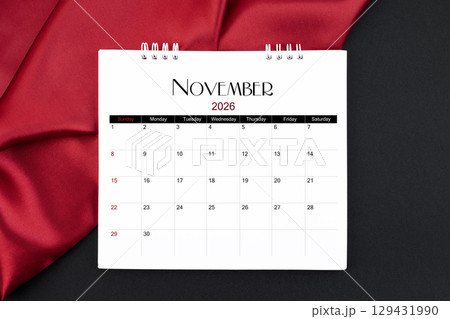 November 2026 Monthly desk calendar with red silk on black color leather background. 129431990