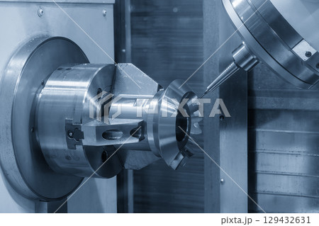 The 5-axis CNC milling machine finish cut the automotive part with solid ball nose end mill tool in the blue tone. 129432631