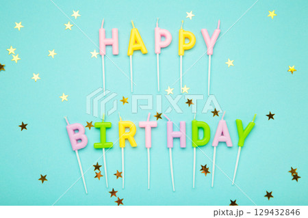 Happy birthday candles with gold stars on blue background Happy birthday candles with gold stars on blue background 129432846