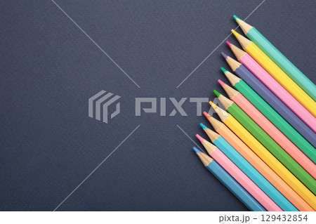 Colorful wooden pencils crayons on dark blue background. Top view. Copy space. Colorful wooden pencils crayons on dark blue background. Top view. Copy space. 129432854