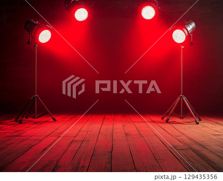 A dimly lit wooden stage is bathed in dramatic, hazy red light from above, creating an empty yet powerful and theatrical atmosphere. A dimly lit wooden stage is bathed in dramatic, hazy red light from above, creating an empty yet powerful and theatrical atmosphere. 129435356