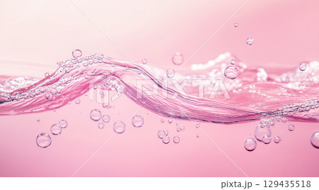 A vibrant splash of clear water creates a dynamic wave and delicate droplets on a calm, reflective pink surface, highlighting its translucent beauty. A vibrant splash of clear water creates a dynamic wave and delicate droplets on a calm, reflective pink surface, highlighting its translucent beauty. 129435518