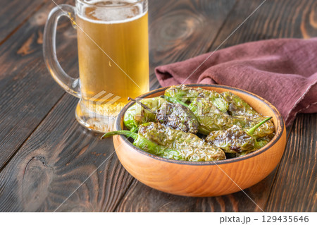 Terracotta bowl of Pimientos de Padron served with cold frothy beer Terracotta bowl of Pimientos de Padron served with cold frothy beer 129435646