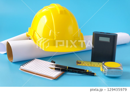 Helmet and tape measure on background,working on construction project. Helmet and tape measure on background,working on construction project. 129435979