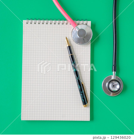 Stethoscope and noted book with pen.Selective focus . Stethoscope and noted book with pen.Selective focus . 129436020
