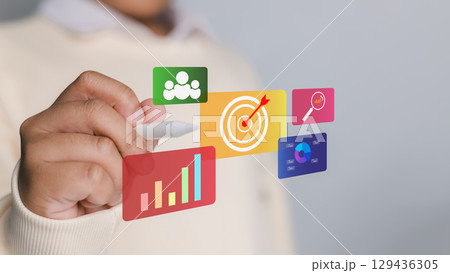 A man hand pointing to business strategy and marketing plan illustration with icons of teamwork, goals, data analysis, and market research, symbolizing success and growth. 129436305