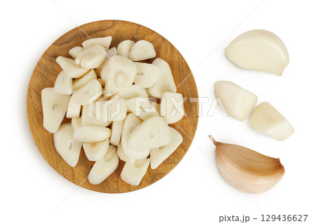 garlic cloves slices in wooden bowl isolated on white background close up. Top view. Flat lay. 129436627