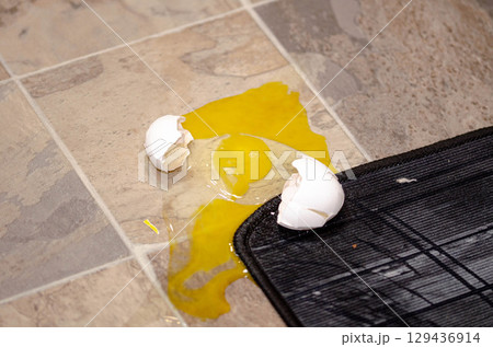 Cracked Broken Egg Spilled on Kitchen Floor Cracked Broken Egg Spilled on Kitchen Floor 129436914