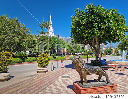 KEMER, TURKEY -  JULY 5, 2025 Kemer Saat Kulesi today Cafe Mokka in the city centrum, with view from Ataturk boulevard. Beautiful Taurus mountains in the background 129437202