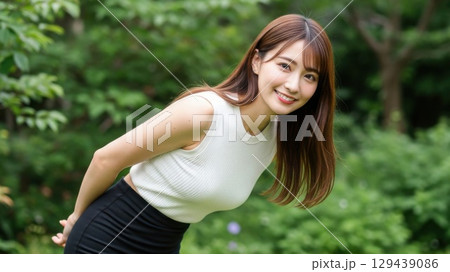 新緑の中でこちらを振り返ってにっこり微笑む20代の女性 新緑の中でこちらを振り返ってにっこり微笑む20代の女性 129439086