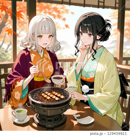紅葉を背にして七輪で団子を焼いている女性二人 129439921