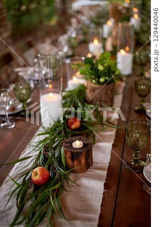 Banquet decoration in a simple rustic style with grass, greenery, simple objects and fabrics. Wedding table setting for guests Banquet decoration in a simple rustic style with grass, greenery, simple objects and fabrics. Wedding table setting for guests 129440046