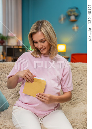 Pregnant woman writing future letter for baby placing envelope on belly smiling hopeful sweet hope 129440195