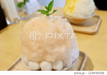 桃シロップをかけたピンク色の大盛りかき氷 桃シロップをかけたピンク色の大盛りかき氷 129440398