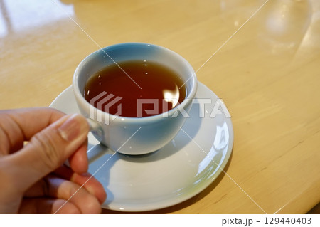 ほうじ茶の入った白いティーカップと木製テーブルの背景 ほうじ茶の入った白いティーカップと木製テーブルの背景 129440403