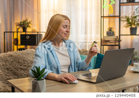 Young woman online laptop shopping at home, adding items, payment success, credit card happy vibe 129440408