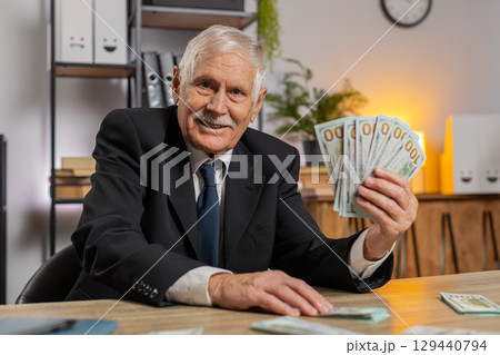 Rich Caucasian senior businessman counting money cash calculate earnings income profit at home 129440794