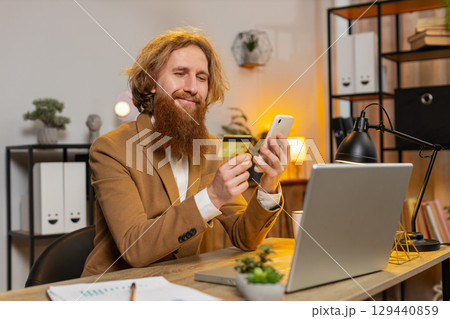 Business man using bank credit card and smartphone for online shopping payments at home office 129440859