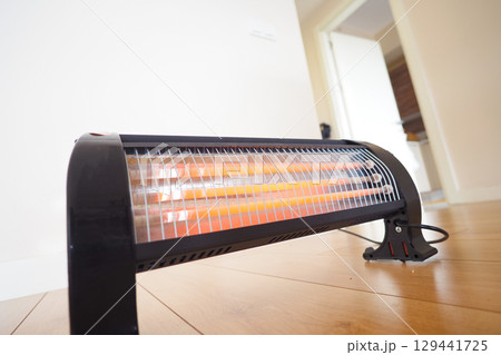 Portable heater providing warmth in a cozy indoor setting 129441725