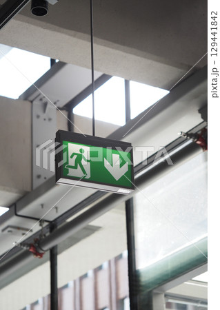 Emergency exit sign displayed in a modern building interior 129441842