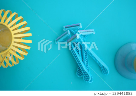Bright blue razors arranged on a turquoise background 129441882