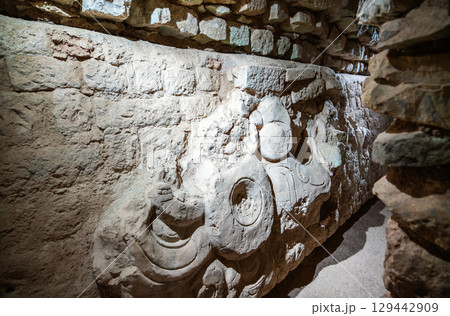 Intricate stone sculpture on a wall inside an archaeological excavation tunnel at the Mayan ruins of Copan, a UNESCO World Heritage site in Honduras 129442909