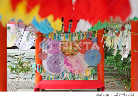 和歌山県春日神社の風鈴まつりで飾られているたくさんのカラフルなてるてる坊主と和傘と風鈴 129443312