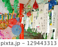 和歌山県春日神社の風鈴まつりで飾られた風に揺れるたくさんの風鈴の短冊とカラフルなてるてる坊主と和傘 129443313