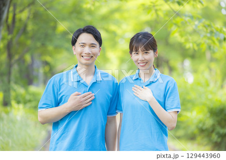 青いポロシャツの男女スタッフ 129443960