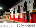 Colorful colonial buildings with traditional wooden balconies decorated for Christmas on a street corner at night in Jardin, Colombia 129444096