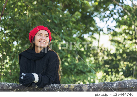 Portrait Asian Woman relaxing in green park. Happy Relax asian woman smiling face at outdoors garden. Young women enjoy nature freedom lifestyle. Greenery wellbeing outside beauty in nature. 129444740