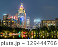 Skyscrapers of Downtown Taipei illuminated at night in Taiwan, reflected in a still water surface, creating a vibrant and symmetrical cityscape scene 129444766