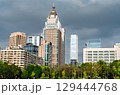View of modern skyscrapers and office buildings in the Taipei city skyline, seen over a lush green park on a cloudy day in Taiwan 129444768