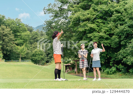 ゴルフ場でゴルフをする女性とスイングを見る女性ゴルファー ゴルフ場でゴルフをする女性とスイングを見る女性ゴルファー 129444870