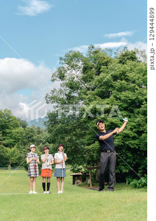 ゴルフ場でティーショットを打つ男性ゴルファーとスイングを見る同伴のゴルファー（ミスショット） 129444899