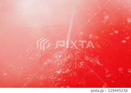 There is a vivid red background adorned with several white spots 129445236