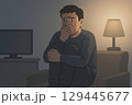 暗い部屋でホラー映画を見る若い男性 129445677
