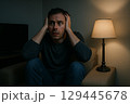 暗い部屋でホラー映画を見る男性 129445678
