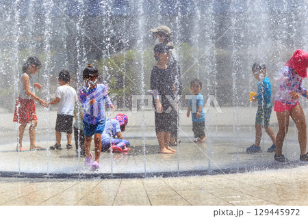 真夏の噴水で水遊びを満喫する子どもたち 129445972