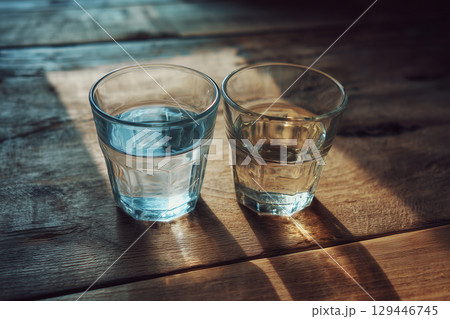 木製テーブルの上に乗せたガラス製のコップ2個をリアルに描いたAI生成画像 木製テーブルの上に乗せたガラス製のコップ2個をリアルに描いたAI生成画像 129446745