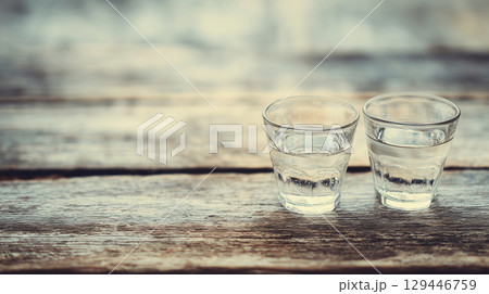 木製テーブルの上に乗せたガラス製のコップ2個をリアルに描いたAI生成画像 木製テーブルの上に乗せたガラス製のコップ2個をリアルに描いたAI生成画像 129446759