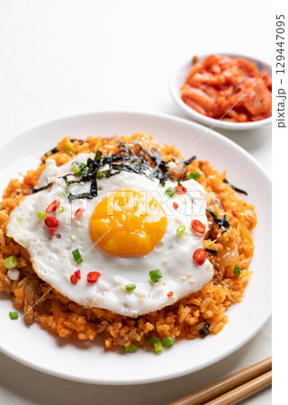 Korean kimchi fried rice with fried egg, pork, sesame seed, chili, spring onion and seaweed 129447095