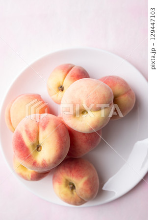Fresh peaches on white plate with pink background, Summer fruit, Top view Fresh peaches on white plate with pink background, Summer fruit, Top view 129447103