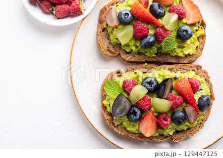 Top view of avocado toast with strawberry, blueberry, raspberry and grape. Healthy eating Top view of avocado toast with strawberry, blueberry, raspberry and grape. Healthy eating 129447125